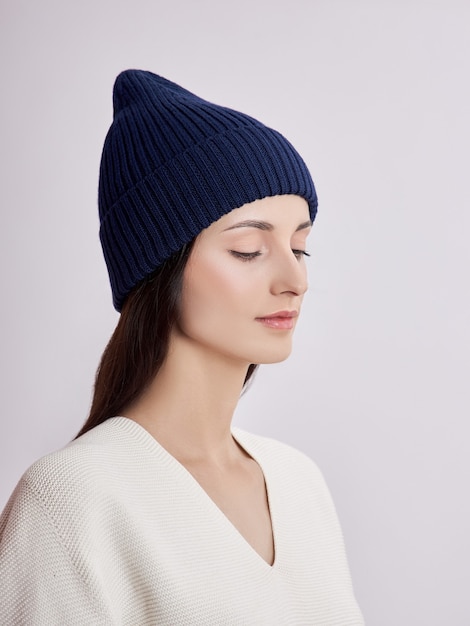 Belle femme au chapeau d'automne sur fond blanc. Vêtements chauds d'automne