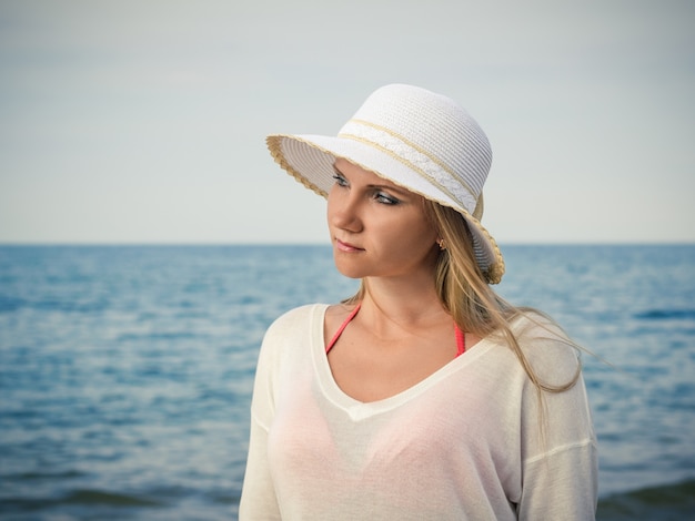 Belle femme au chapeau blanc avec des cheveux qui coule