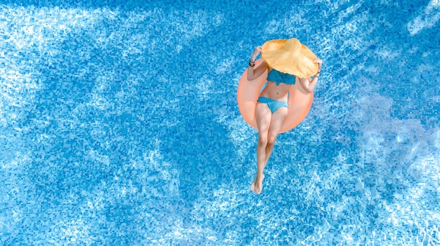 Belle femme au chapeau dans la piscine vue aérienne de dessus d'en haut jeune fille en bikini se détend