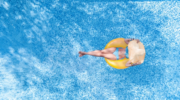 Belle femme au chapeau dans la piscine vue aérienne de dessus d'en haut