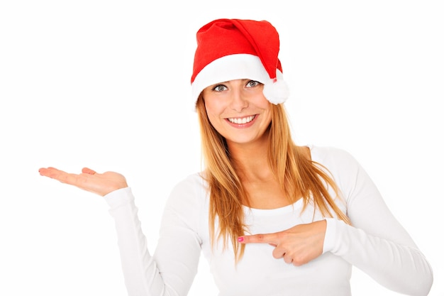 une belle femme au chapeau du père Noël avec sa main montrant votre produit sur blanc