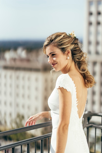 Belle femme aux cheveux blonds vêtue de blanc le jour de son mariage avant de se marier.