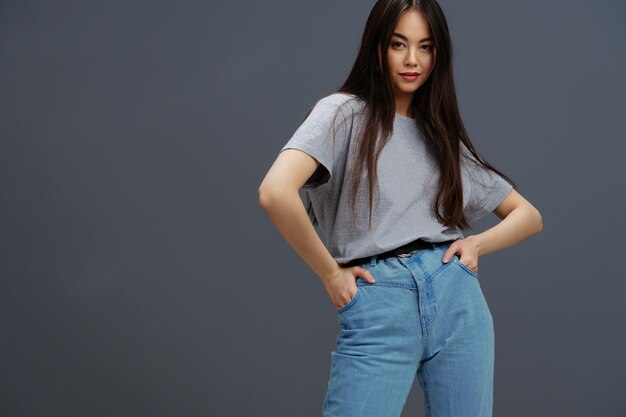 Belle femme aux cheveux longs dans un Tshirt gris gesticulant avec les mains