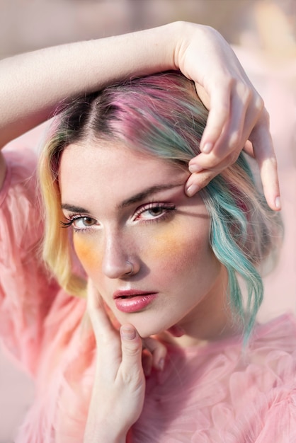Belle femme aux cheveux rose et turquoise, avec un maquillage artistique professionnel