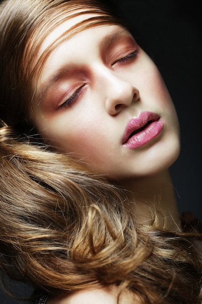 Belle femme aux longs cheveux blonds bouclés.