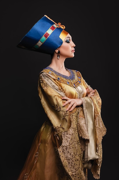 Belle femme aux yeux marrons et maquillage de soirée en tant que reine Néfertiti