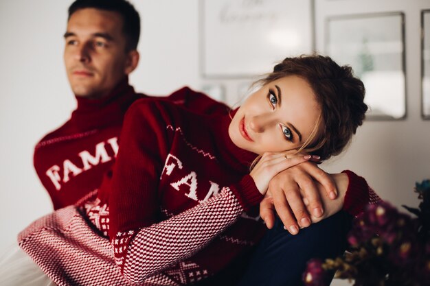 Belle femme et beau petit ami posant en pulls rouges