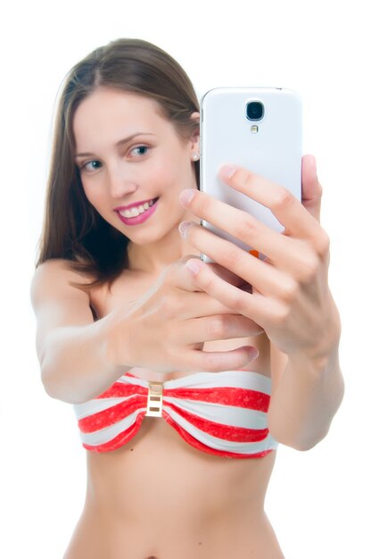 Belle femme en bikini prenant selfie photo sur son téléphone