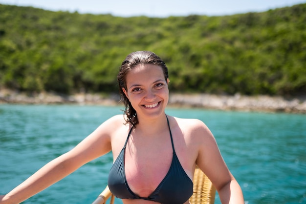 Belle femme en bikini vert sur la plage tropicale Portrait de jeune femme heureuse souriant à la mer