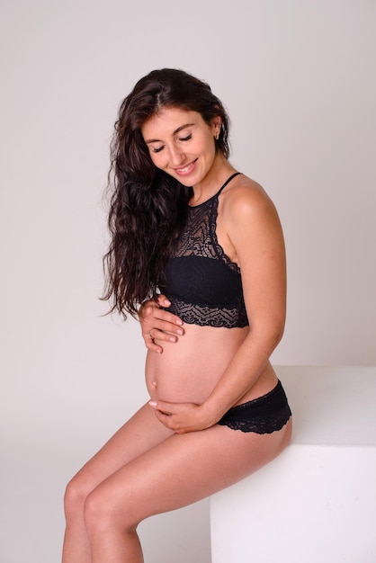 Belle femme blanche enceinte étreignant son ventre profitant de son espace libre de grossesse