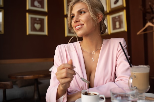 Belle femme blonde assise au café