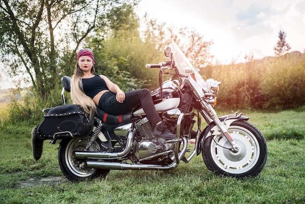 Une belle femme blonde assise sur une moto