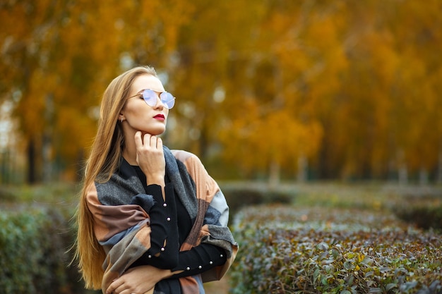 Belle femme blonde aux cheveux longs posant dans la forêt d'automne. Photo en gros plan. Espace pour le texte