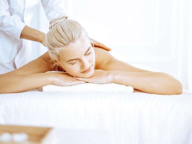 Belle femme blonde bénéficiant d'un massage du dos au centre de spa Beauté et style de vie