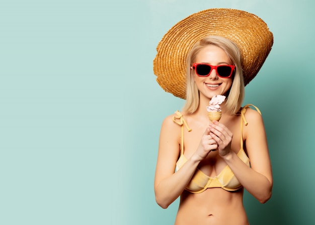 Belle femme blonde en bikini avec une glace