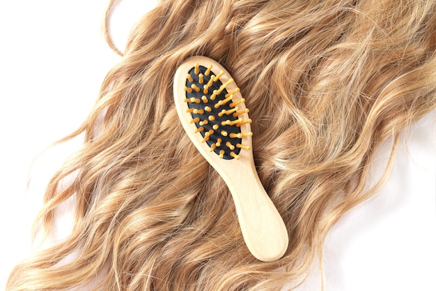 Belle femme blonde cheveux ondulés et brosse à peigne en bambou vue aérienne