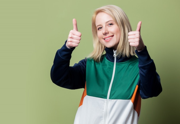 Belle femme blonde en costume de sport des années 90 montre le geste OK