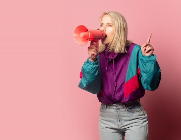 Belle femme blonde dans des vêtements des années 90 avec haut-parleur