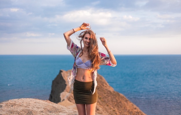 Belle femme blonde en été contre la mer