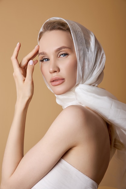 Belle femme blonde avec un grand foulard blanc