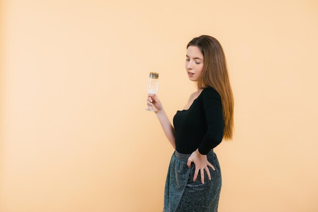 Belle femme blonde heureuse en robe courte sexy avec une coupe de champagne fête son anniversaire