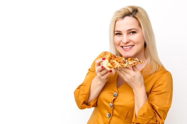 Belle femme blonde mangeant un morceau de pizza