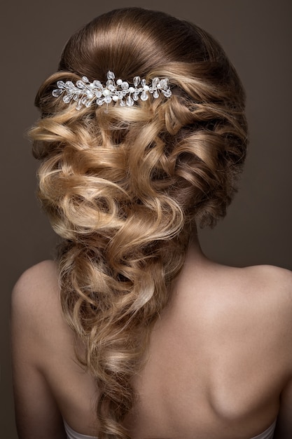 Photo belle femme blonde avec une peau parfaite, maquillage de soirée, coiffure de mariage et accessoires