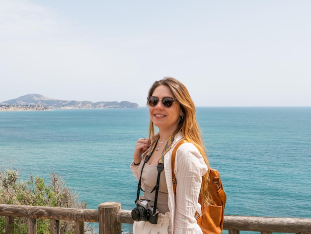 belle femme blonde sur la plage avec un appareil photo