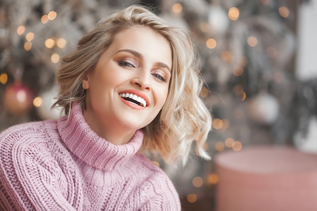 Belle femme blonde près de l'arbre de Noël