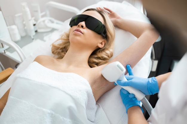 Belle femme blonde sur la procédure d'épilation au laser des aisselles