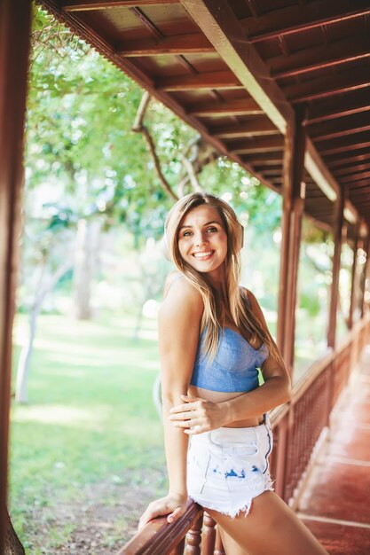 Belle femme blonde souriante avec un casque dans un complexe tropical