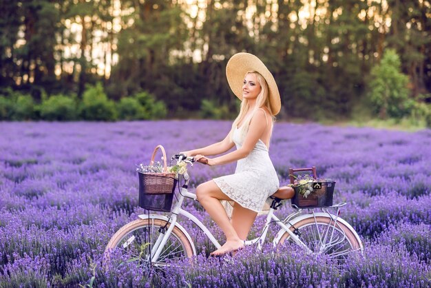 Belle femme blonde avec un vélo à la lavande.