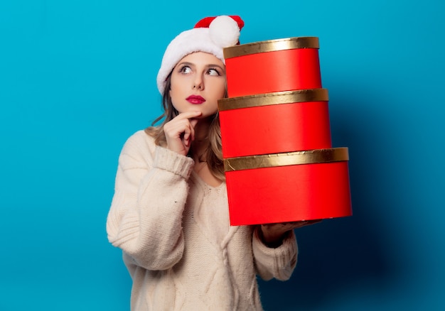 Belle femme avec une boîte cadeau sur le mur bleu