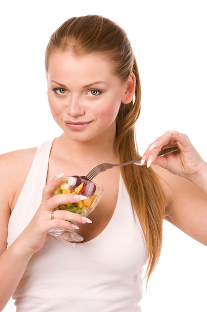 Belle femme avec un bol en verre de salade de fruits