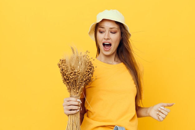 Belle femme bouquet de fleurs séchées vêtements décontractés sourire posant fond isolé