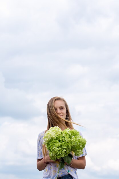 Belle femme avec un bouquet d'hortensias