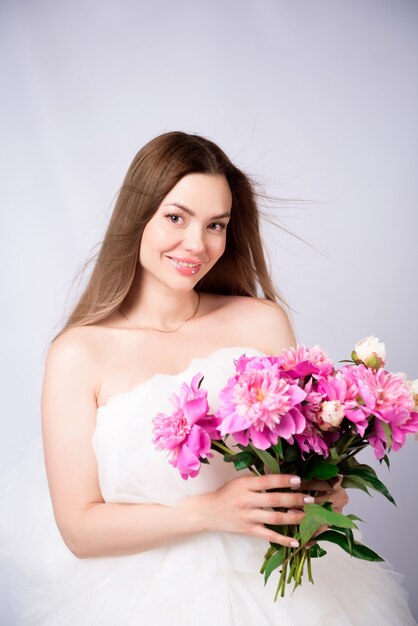 Belle femme bouquet de pivoines en fleurs