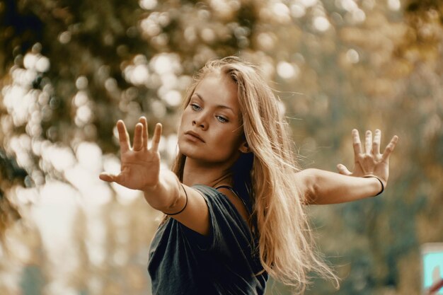 Une belle femme avec les bras tendus debout à l'extérieur