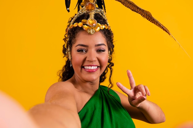 Belle femme brésilienne afro avec la tête du danseur pour le carnaval faisant un selfie