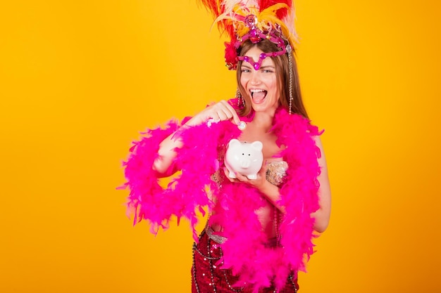 Belle femme brésilienne blonde avec des vêtements de reine du carnaval de l'école de samba Couronne de plumes tenant une tirelire et une pièce