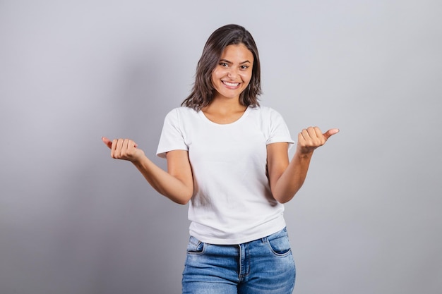 Belle femme brésilienne denim et blanc invitant avec les mains appelant bienvenue venez présenter accueillant