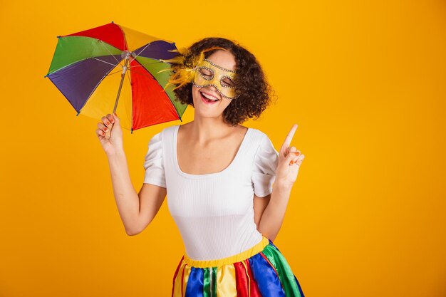 Belle femme brésilienne habillée en jupe colorée de vêtements de carnaval et chemise blanche portant la danse de mascara