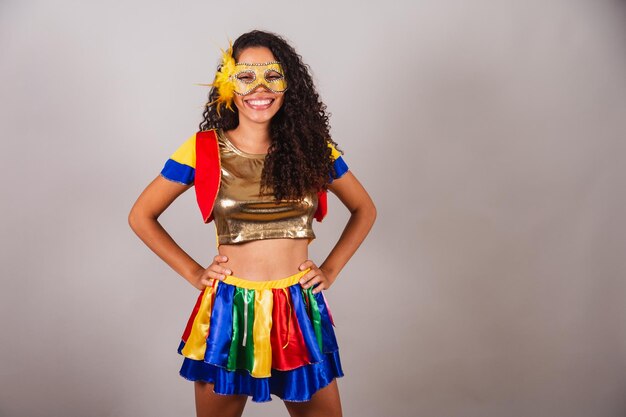 Belle femme brésilienne noire avec carnaval de vêtements frevo portant un masque les mains sur la taille