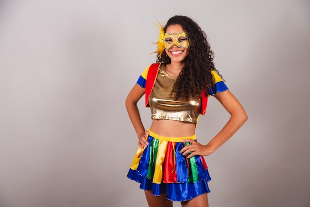 Belle femme brésilienne noire avec carnaval de vêtements frevo portant un masque les mains sur la taille