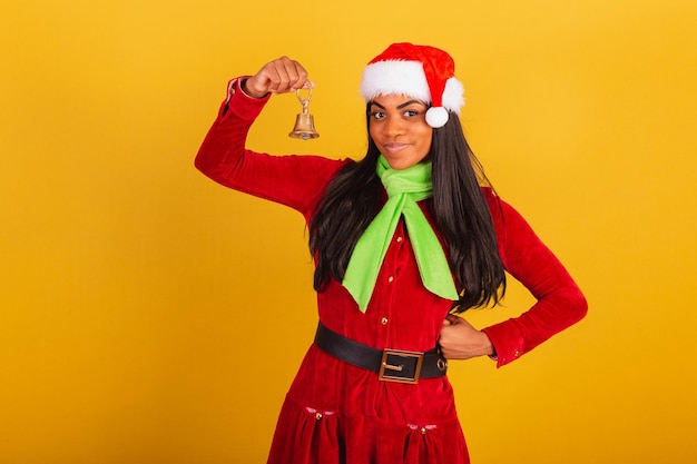 Photo belle femme brésilienne noire vêtue de vêtements de noël le père noël tenant la cloche de noël