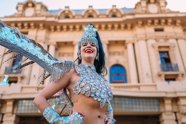 Belle femme brésilienne portant un costume de carnaval coloré et souriant pendant le défilé de rue du Carnaval en ville.