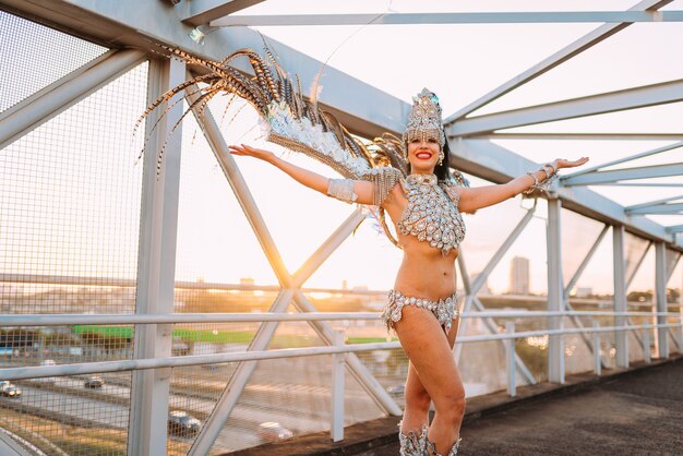 Belle femme brésilienne portant un costume de carnaval coloré et souriant pendant le défilé de rue du Carnaval en ville.