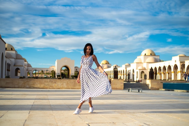 Une belle femme bronzée en robe noire d'été