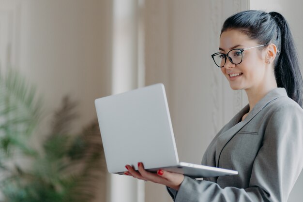 Belle femme brune à l'aide d'un ordinateur portable