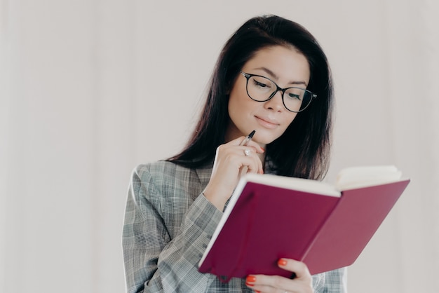 Belle femme brune écrit dans un bloc-notes